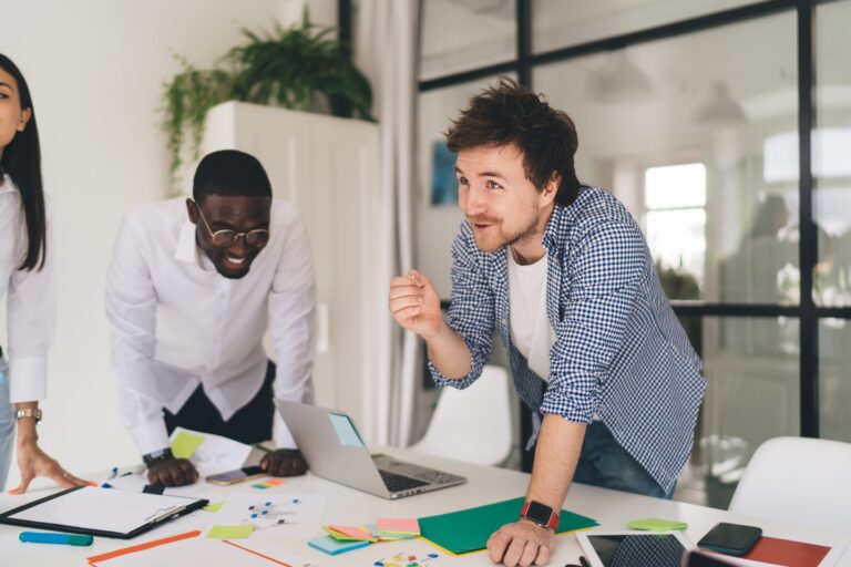 Ethnic man explaining point of view while diverse colleagues laughing